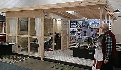 Assembled Allwood Solvalla cabin with glazed section and open deck at an indoor showroom